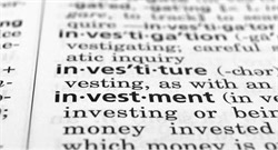 Closeup of the word "investment" appears in a black and white dictionary amongst a list of other words.